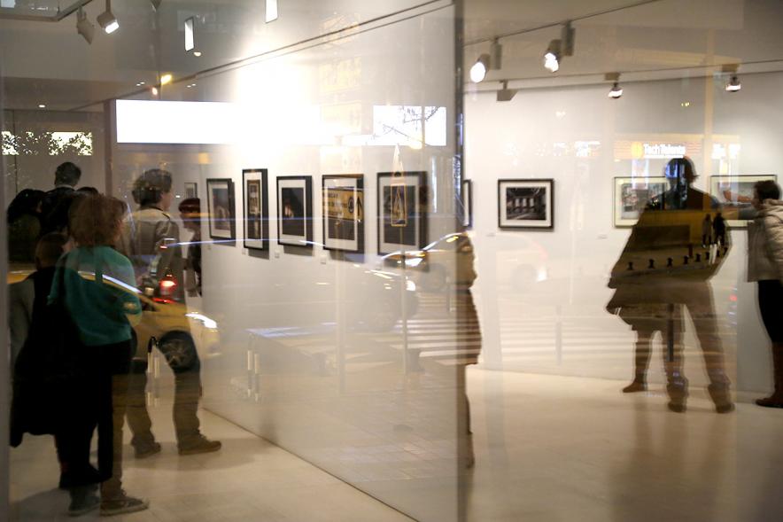 Exposición VIIº Concurso de Fotografía Ciudad de Alcobendas - Imagen de personas asistentes a la exposición mirando las obras expuestas.