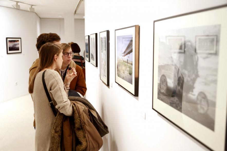 Exposición VIIº Concurso de Fotografía Ciudad de Alcobendas - Imagen de personas asistentes a la exposición mirando las obras expuestas.
