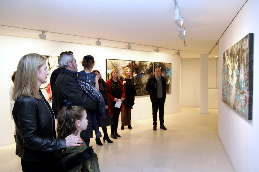 Inauguración de la Exposición de Manuel Martín Cabrera - Imagen de unas personas admirando uno de los cuadros expuestos en la exposición.