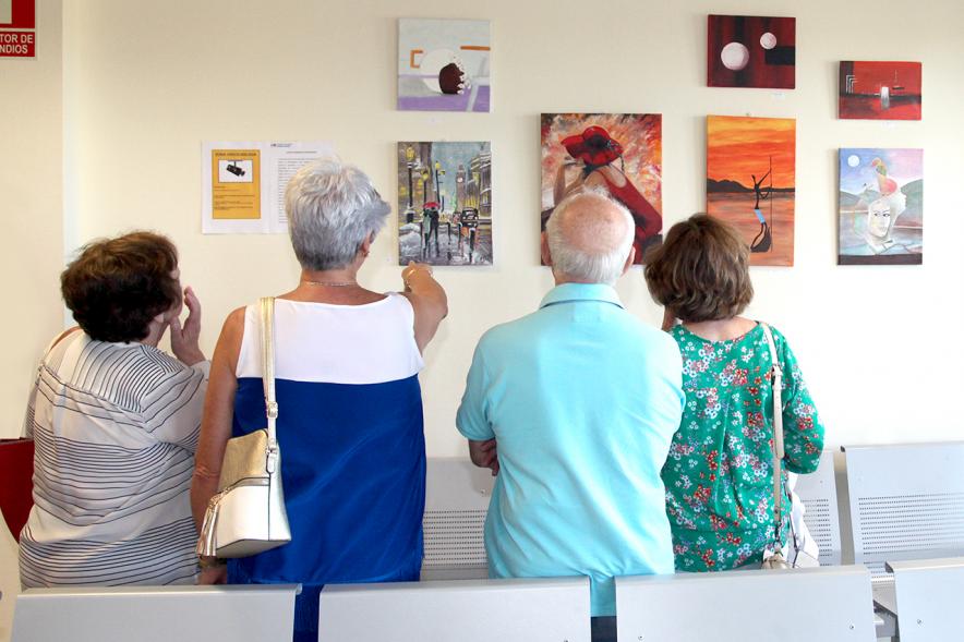 Inauguración Exposición Pintura en el Hospital Infanta Sofía - imagen de personas admirando algunos de los cuadros expuestos.