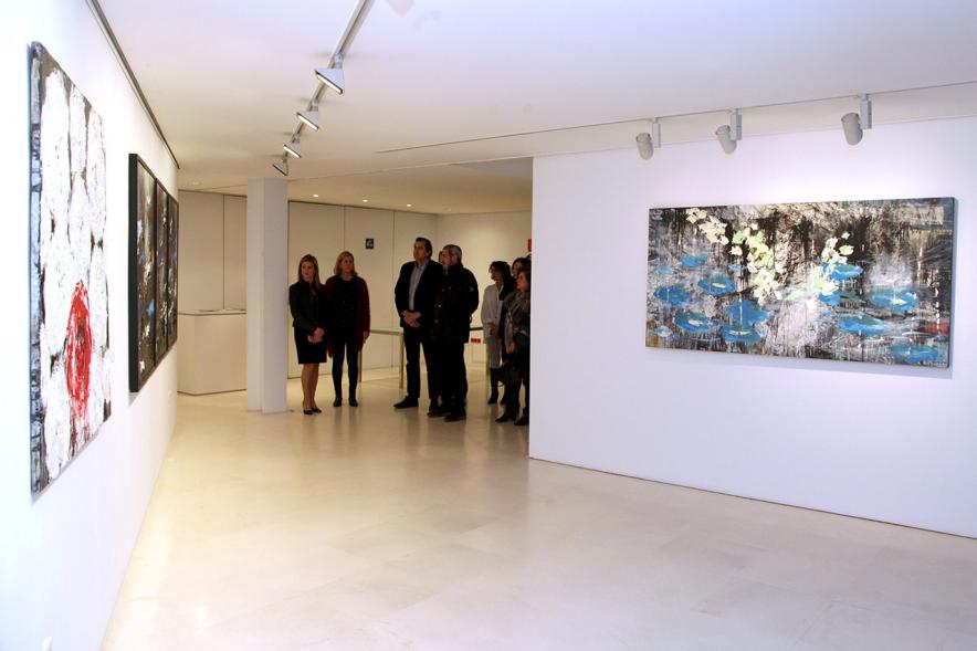Inauguración de la Exposición de Manuel Martín Cabrera - Imagen lejana del autor de la exposición Manuel Martín Cabrera con las autoridades explicándoles algunas de sus obras.