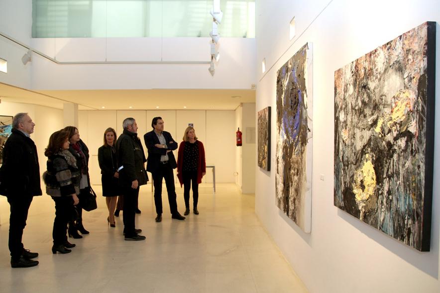 Inauguración de la Exposición de Manuel Martín Cabrera - Imagen lejana del autor de la exposición Manuel Martín Cabrera con las autoridades explicándoles algunas de sus obras.