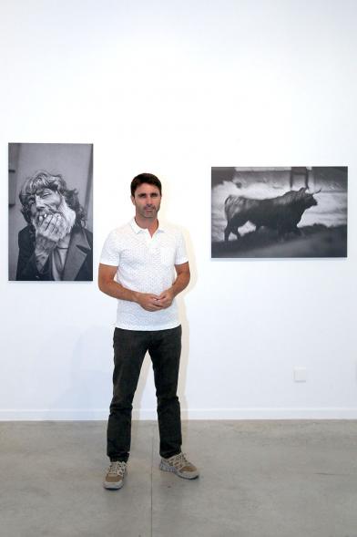 Fotógrafo Aitor Lara, posando con dos de sus fotos. 