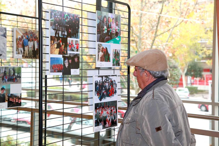 Inauguración Exposición Voluntariado en C.C. Pablo Iglesias - Imagen de una persona mirando la fotografías expuestas en la Exposición Voluntariado.