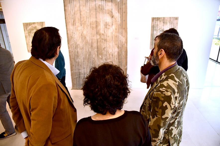 Delegación municipal y autor observando una obra