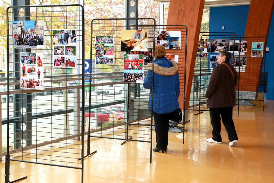 Inauguración Exposición Voluntariado en C.C. Pablo Iglesias - Imagen de personas mirando la fotografías expuestas en la Exposición Voluntariado.