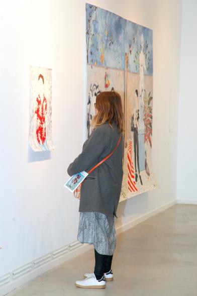 Inauguración Exposición "Se non è Vero, è Ben Trovato" de Los Bravú - Primer plano de una visitante observando dos obras.