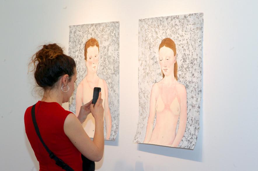 Inauguración Exposición "Se non è Vero, è Ben Trovato" de Los Bravú -  Primer plano de dos obras junto a una visitante.