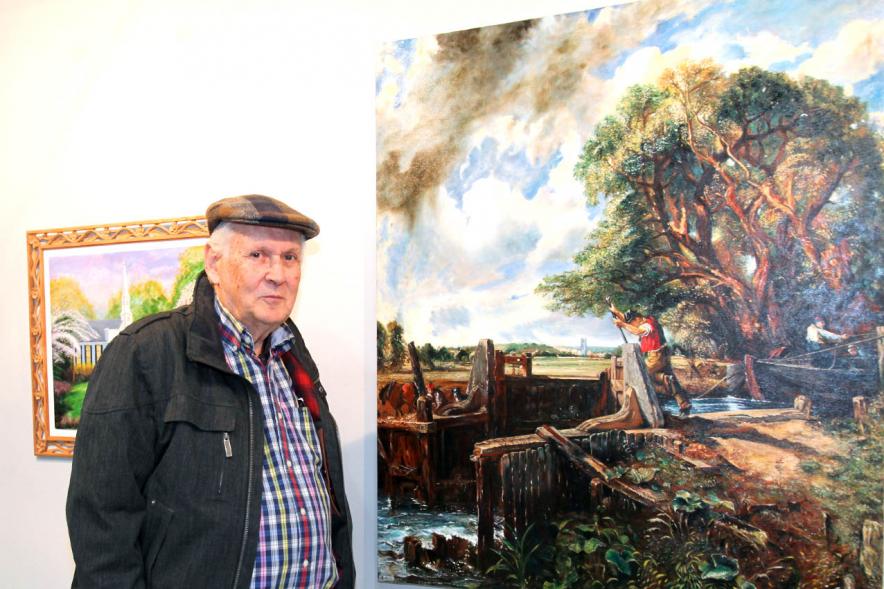 Artista participante junto a su obra.