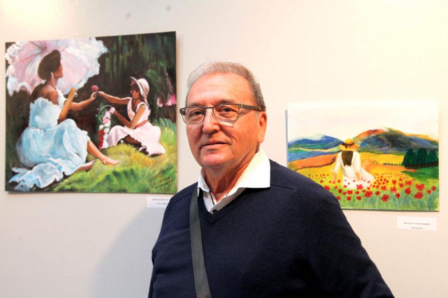 Artista participante junto a su obra.