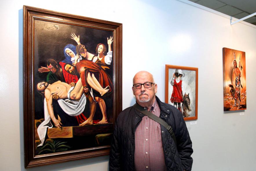 Artista participante junto a su obra.