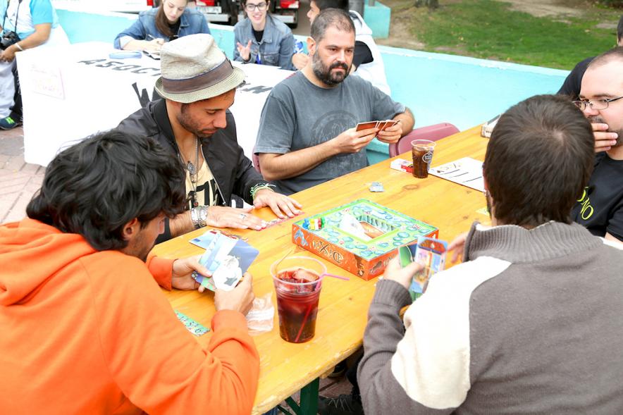 Feria Asociativa Juvenil - Participantes feria jugando a un juego de mesa.