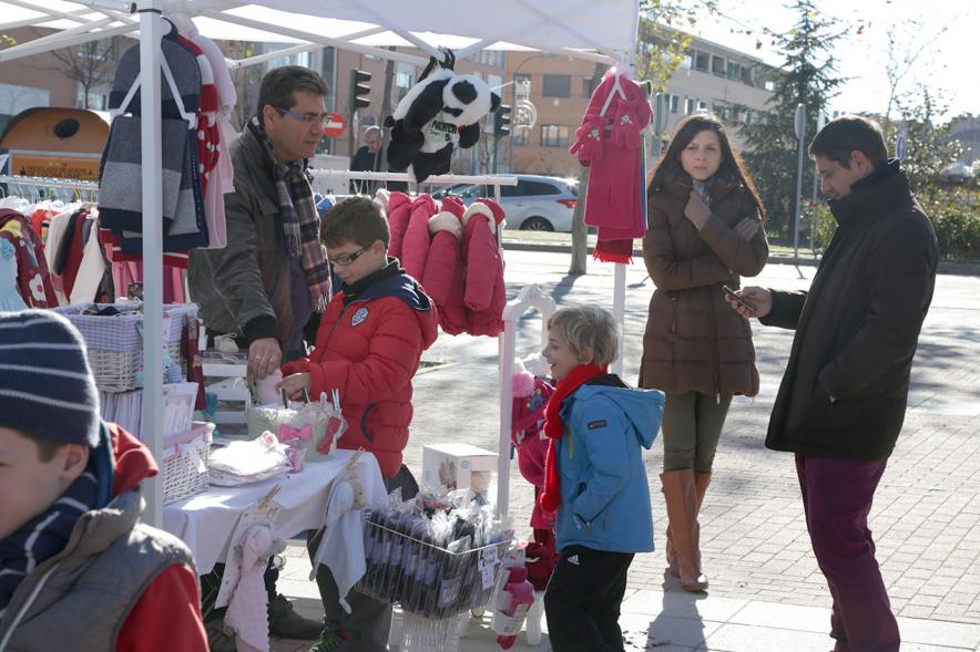 Feria de Compras al Aire Libre en el Paseo de Valdelasfuentes - Imagen de un puesto de la feria rodeado de personas.