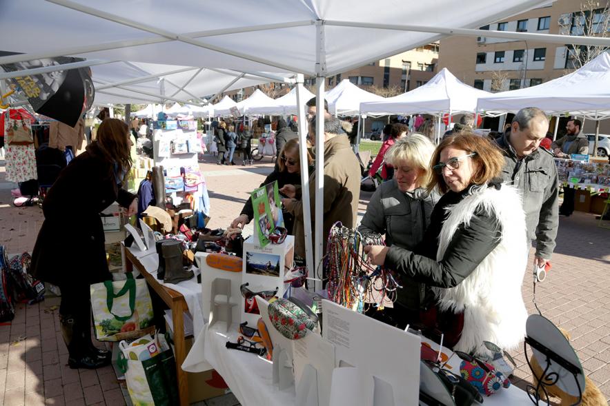 Feria de Compras al Aire Libre en el Paseo de Valdelasfuentes - Imagen de un puesto de la feria rodeado de personas.
