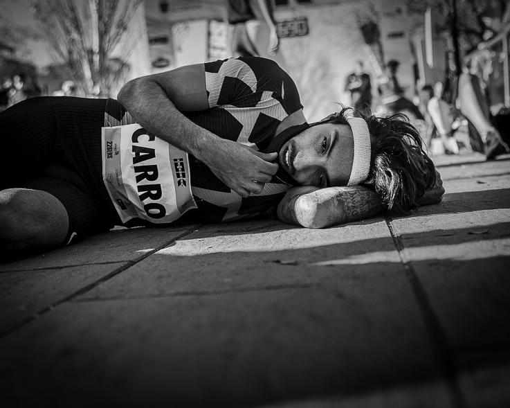 Fernando Carro Gana 10K con la Mejor Marca Española de la Historia en 10 Km - Imagen primer plano en blanco y negro de del atleta Fernando Carro tirado en el suelo después de terminar la carrera.