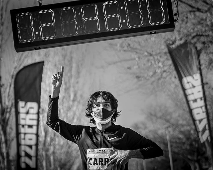 Fernando Carro Gana 10K con la Mejor Marca Española de la Historia en 10 Km - Imagen en blanco y negro del atleta Fernando Carro marcando la marca que acaba de batir 27 minutos 46 segundos.