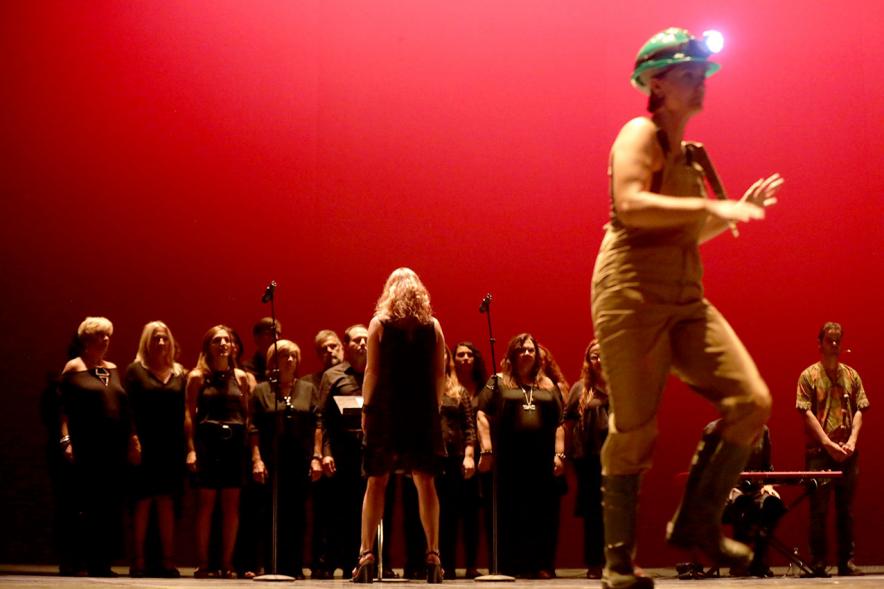 Festival Internacional de Danza y Artes Escénicas ADAE Ciudad de Alcobendas -  El escenario con una bailarina y el coro.