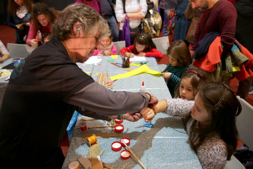 Fiesta Derechos de la Infancia - Imagen de una coordinadora poniéndole una calcomanía  a una niña.