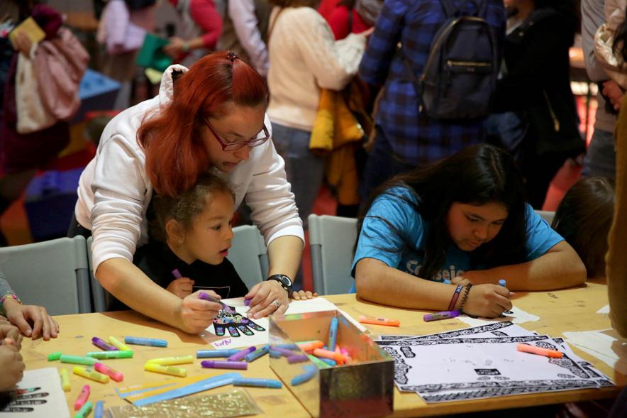 Fiesta Derechos de la Infancia - Imagen de una monitora enseñando unos juegos a los niños.