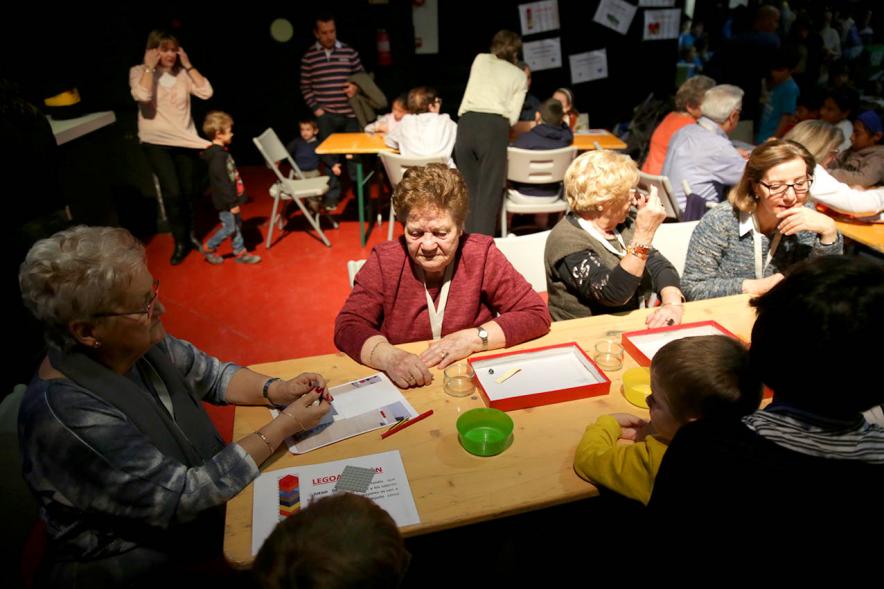 Fiesta Derechos de la Infancia - Primer plano de un grupo de participantes mayores en una mesa  de actividades.