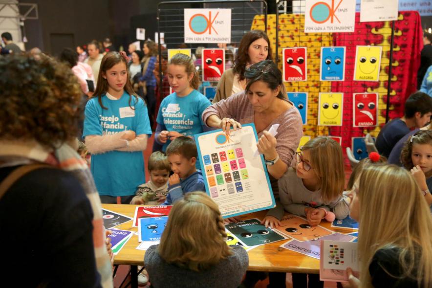 Fiesta Derechos de la Infancia - Imagen de los niños en la mesa de actividades infantiles con una monitora.