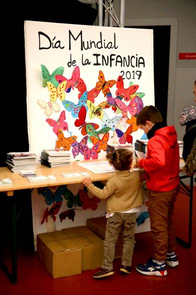 Fiesta Derechos de la Infancia - Primer plano del cartel del evento con unos niños mirándolo.
