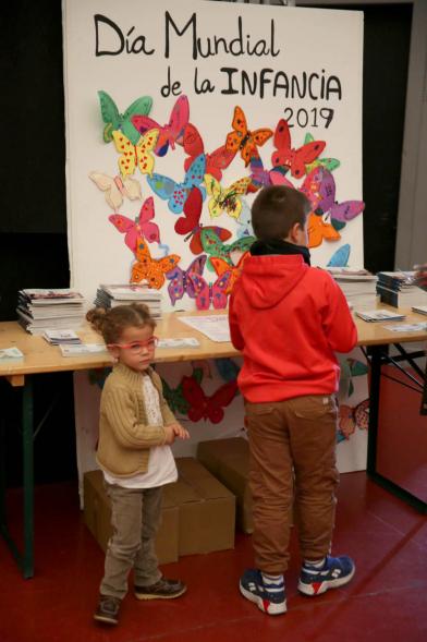 Fiesta Derechos de la Infancia - Primer plano del cartel del evento con unos niños mirándolo.
