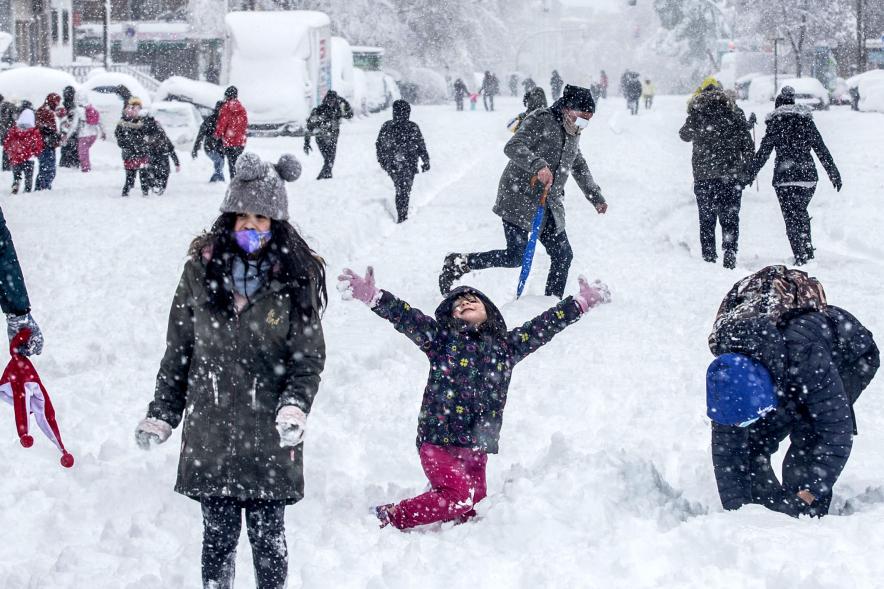 Gente divirtiéndose en la calle mientras nieva