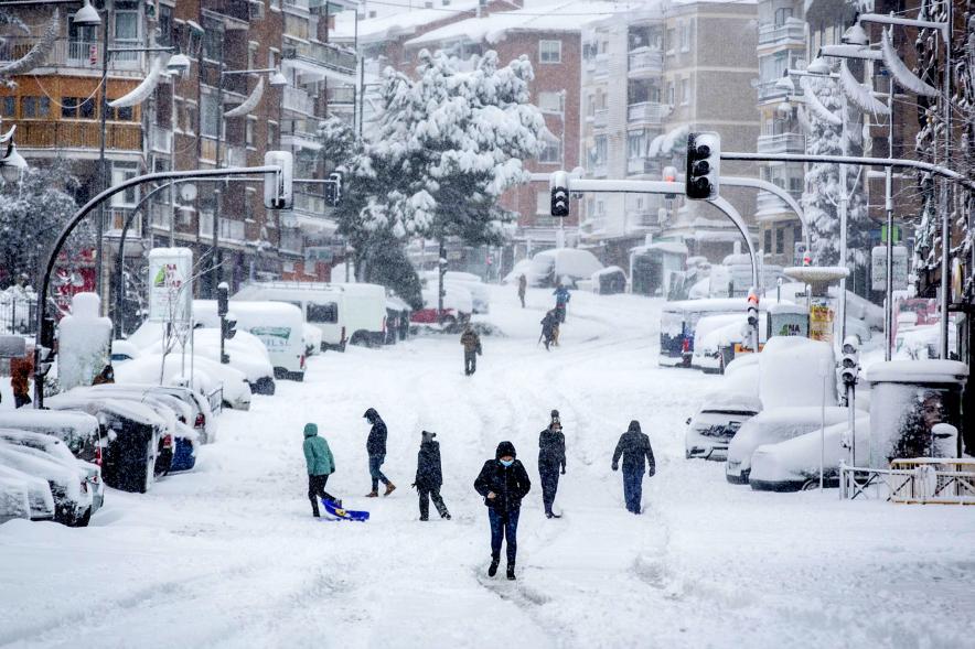 Gente divirtiéndose en la calle mientras nieva