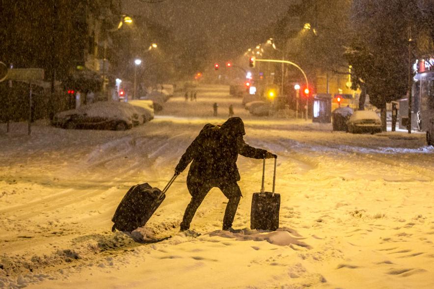 Cruzando con maletas las calles nevadas