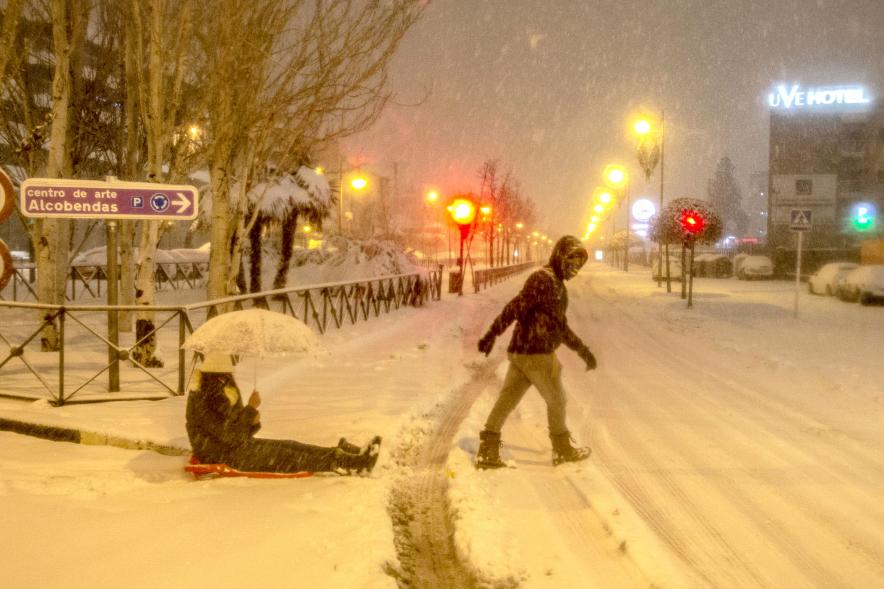 Ciudadanos con trineo jugando en las calles nevadas