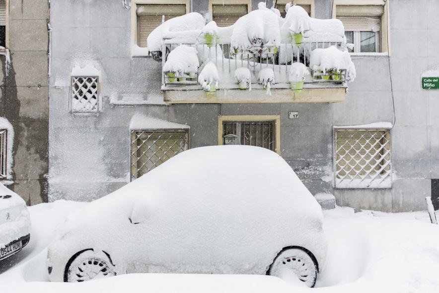 Coche, calle y terraza totalmente cubiertos por la nieve