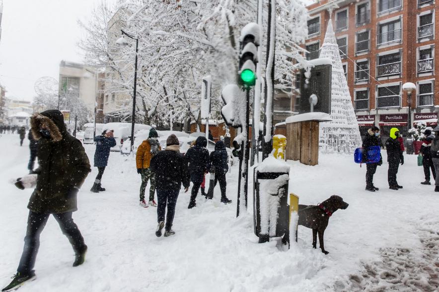 Gente divirtiéndose en la calle mientras nieva