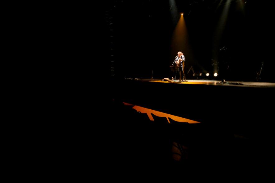 Concierto Folk Día de Castilla La Mancha - Imagen del escenario oscurecido con un músico.