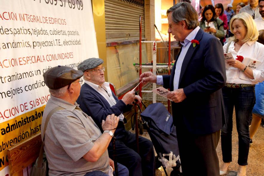 Alcalde García de Vinuesa entregando claveles y programa de fiestas