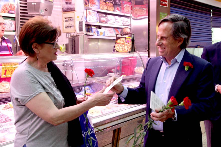 Alcalde García de Vinuesa entregando claveles y programa de fiestas