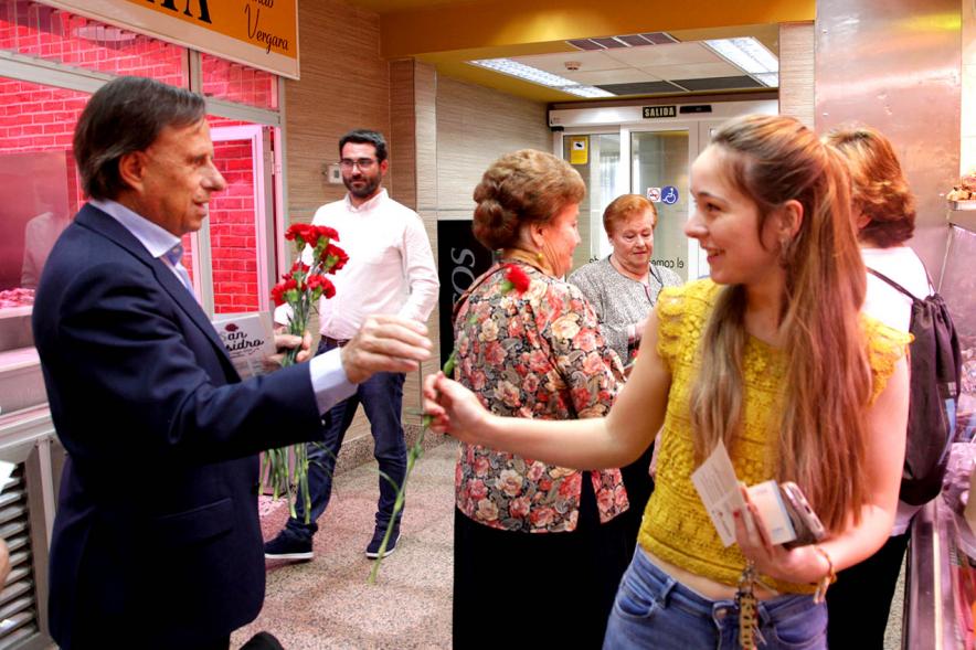 Alcalde García de Vinuesa entregando claveles y programa de fiestas