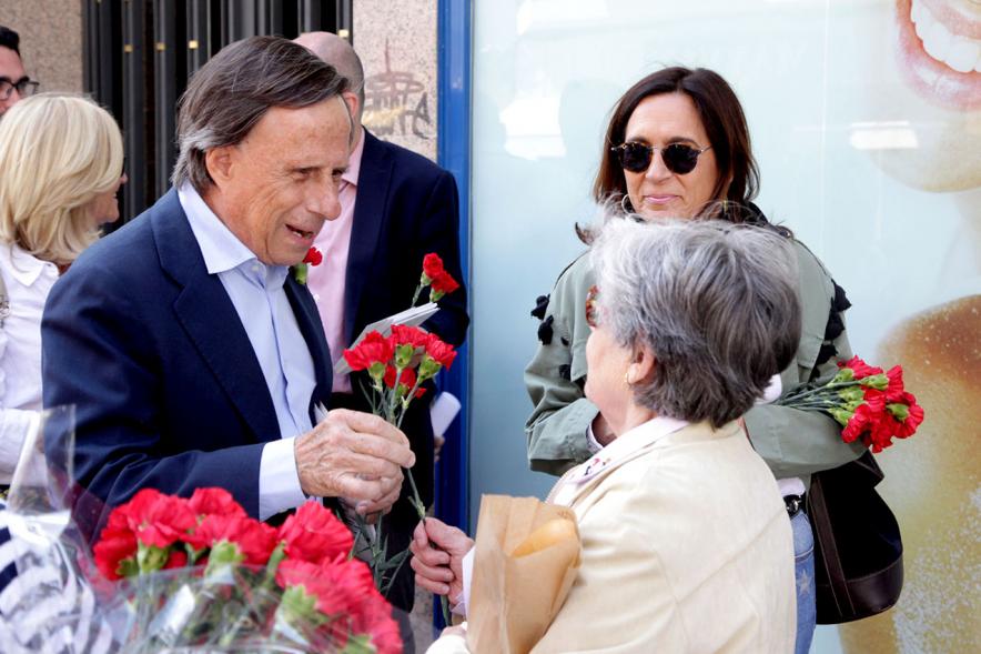 Alcalde García de Vinuesa entregando claveles y programa de fiestas
