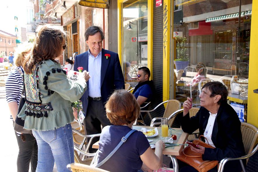 Delegación municipal hace entrega del programa de fiestas a ciudadanos en una terraza de verano