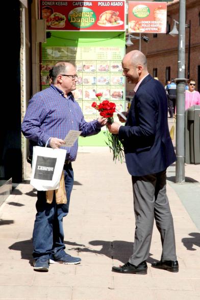 Concejal Cubián Martínez entregando claveles y programa de fiestas
