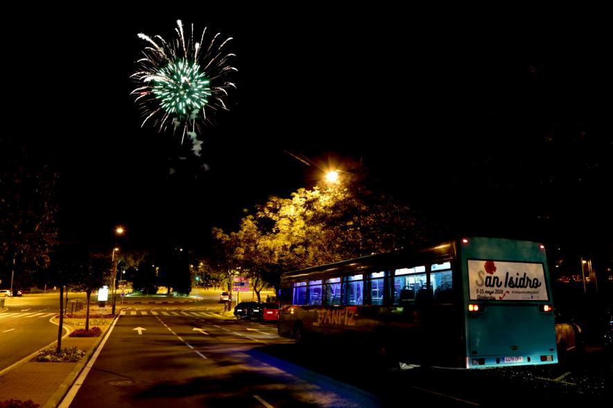 Detonaciones en el cielo con autobus en primer plano