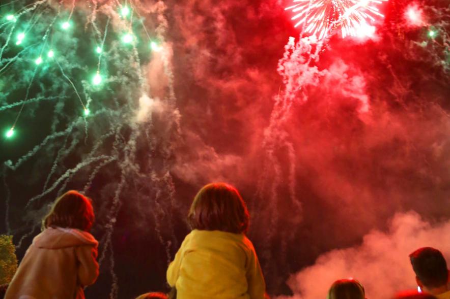 Niños disfrutando del espectáculo con detonaciones al fondo
