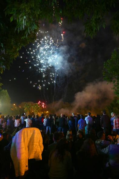 Vista amplia de público con detonaciones al fondo