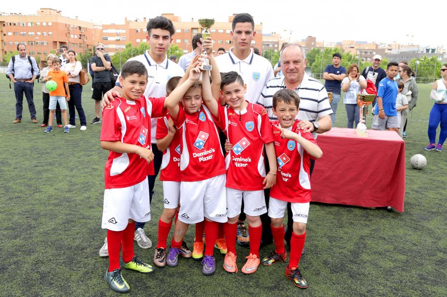 Equipo infantil levantando trofeo