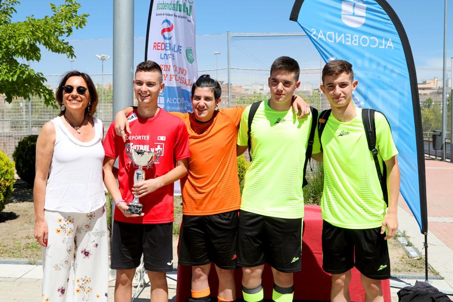 Torneo de Fútbol Sala Alcobendas Futsal -  Imagen de un grupo de jugadores con su trofeo posando junto a la persona que se lo ha entregado.