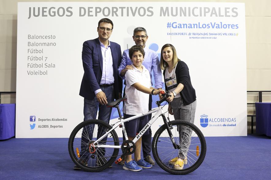 Entrega de trofeos XXII Juegos Deportivos Municipales -  Posado de un deportista infantil con una bicicleta como premio junto a las autoridades municipales. 