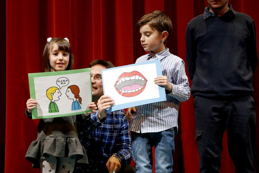 Gala APAMA 2019 - Primer plano de dos niños enseñando unos carteles divertidos.