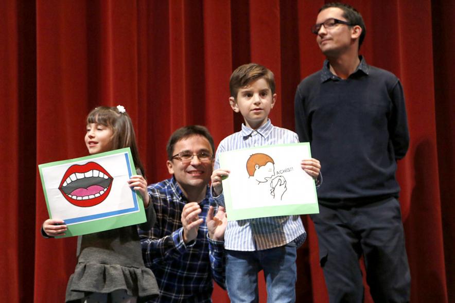 Gala APAMA 2019 -  Primer plano de dos niños enseñando unos carteles divertidos.
