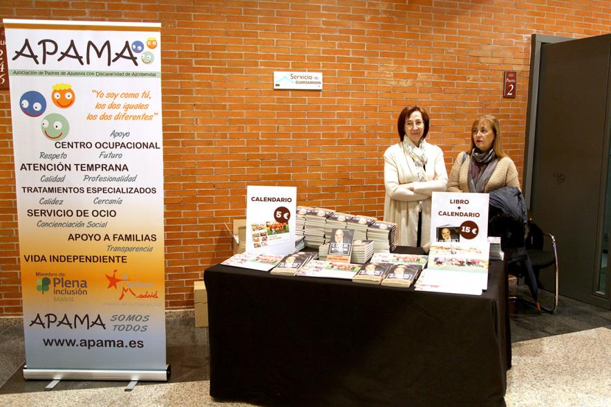 Gala Homenaje a la Solidaridad - Imagen de un rincón del hall donde se encuentra un cartel publicitario y una mesa donde se vende un libro y un calendario.