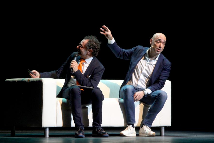 Gala Homenaje a la Solidaridad - Imagen del escenario, donde están sentados en un sofá charlando el mago More y el empresario Cipri Quintas,.